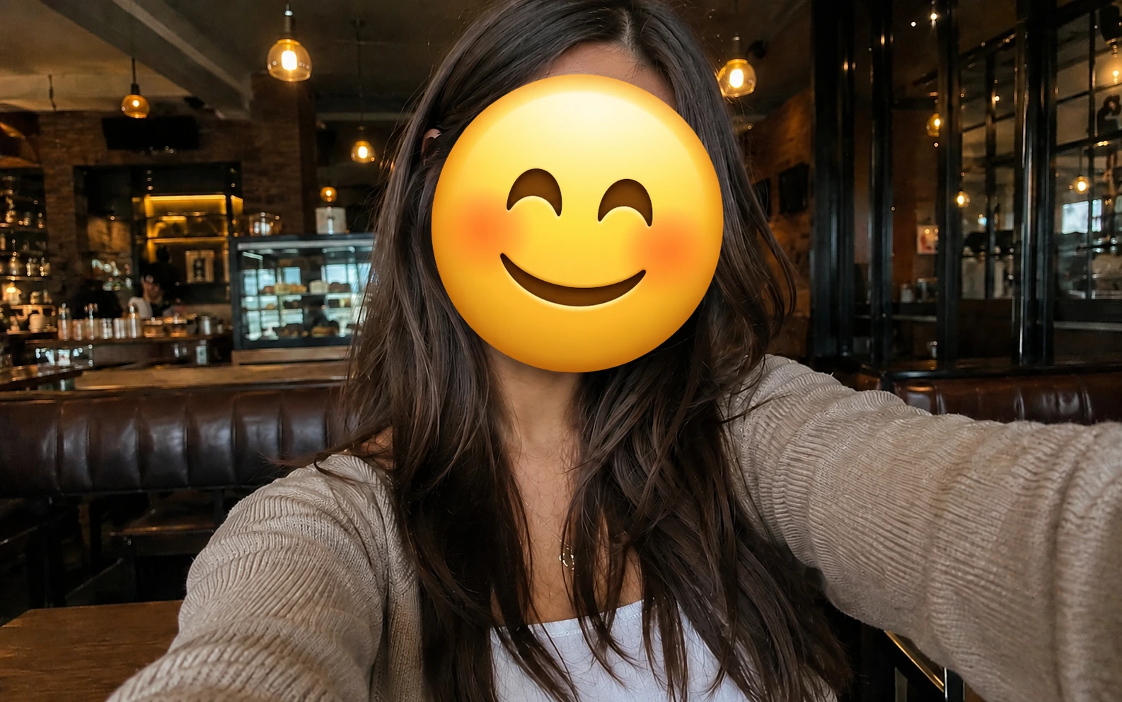 Before-and-after comparison of a cafe selfie with the face covered by a smiling emoji.