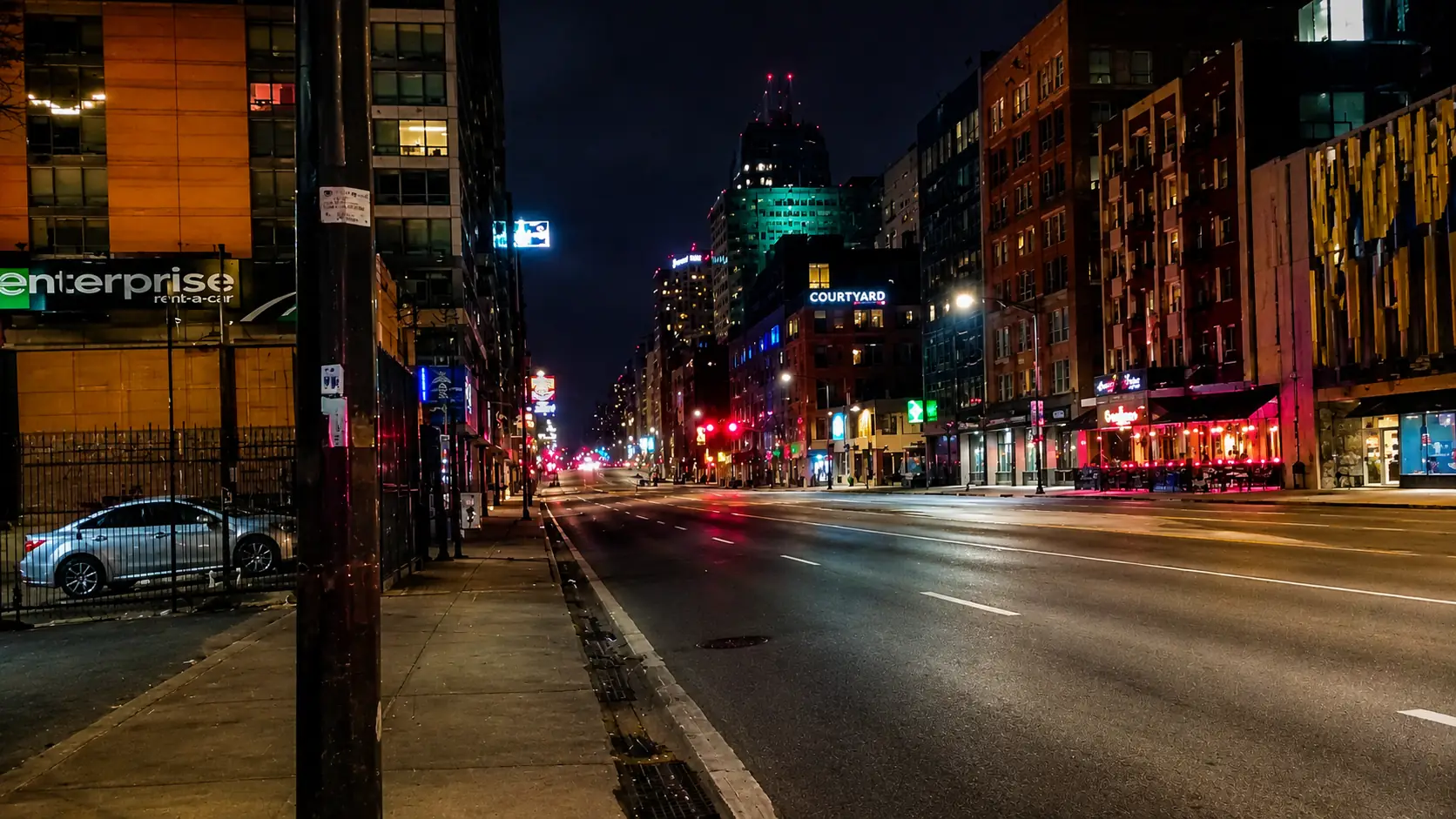 Before-and-after slider for a noisy low-light city street cleaned for better contrast and detail. overlay