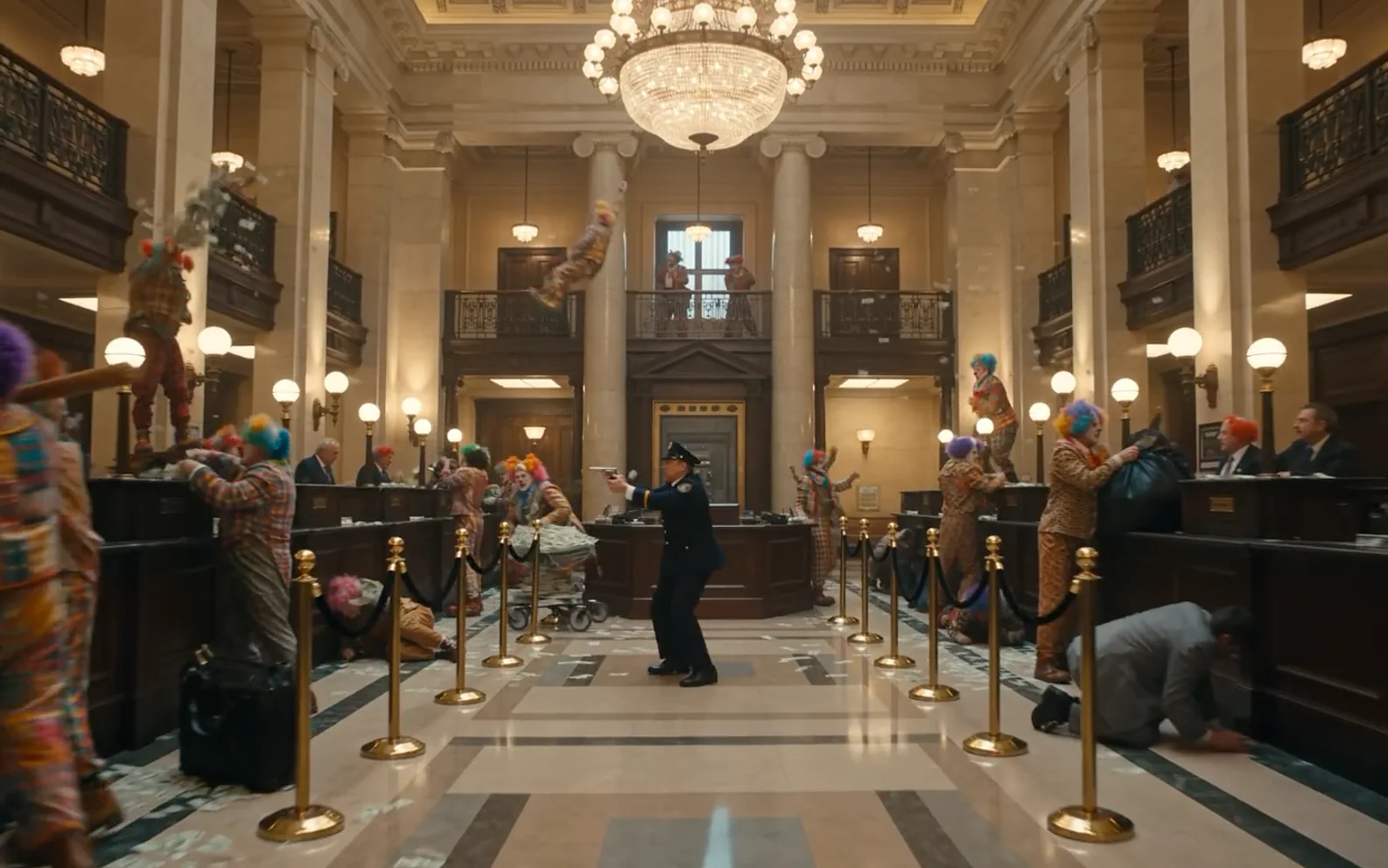 Live-action bank lobby filled with colorful clowns as a uniformed police officer reacts in the center aisle.