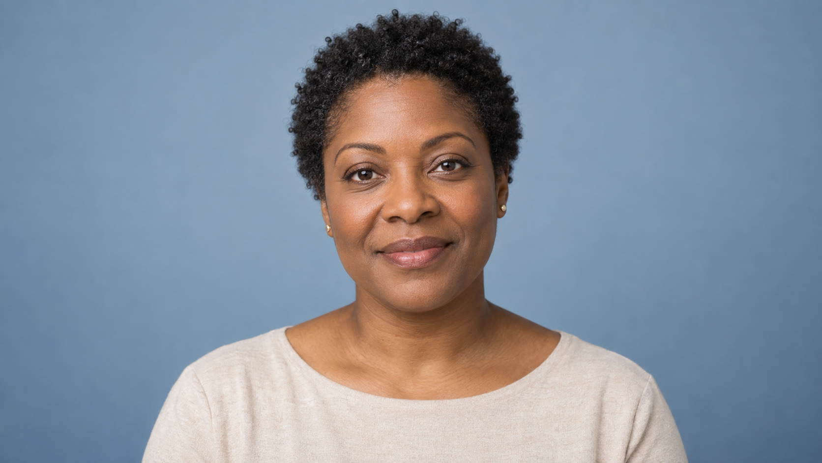 Woman with short natural hair in a light beige top