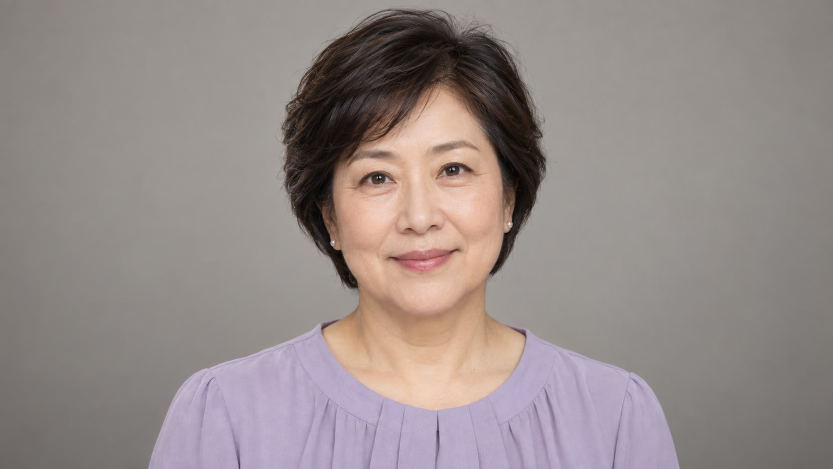 Woman with short dark hair in a lavender blouse